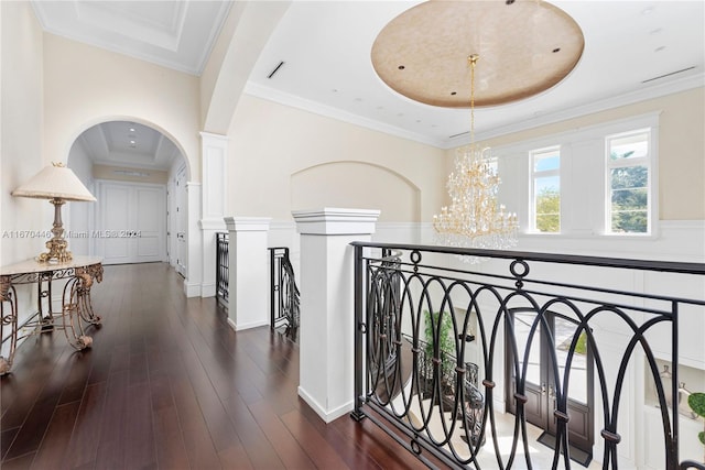 hall with a notable chandelier, a raised ceiling, and dark hardwood / wood-style floors