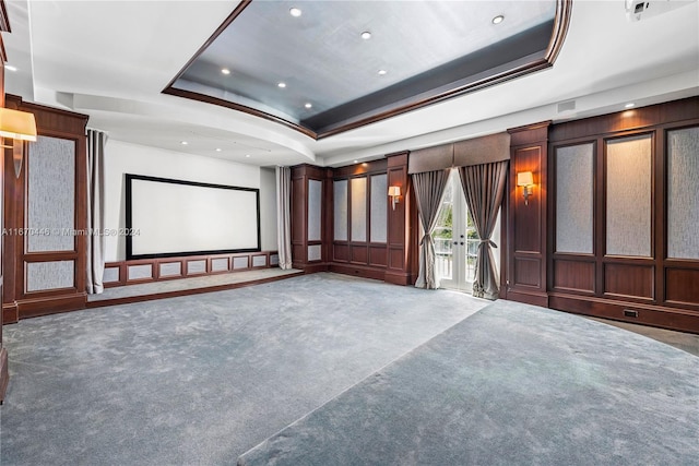 cinema room featuring carpet, a tray ceiling, and french doors