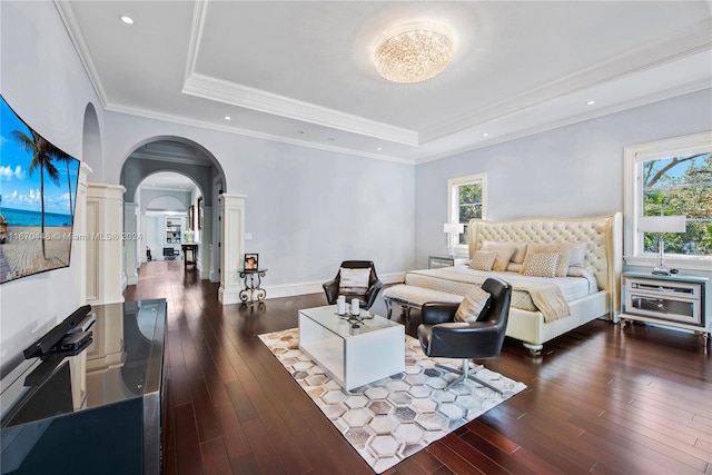 bedroom featuring ornamental molding, a tray ceiling, dark hardwood / wood-style flooring, and multiple windows