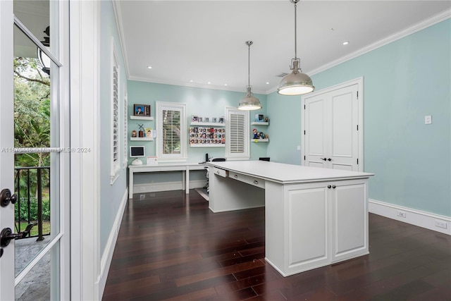 kitchen featuring built in desk, hanging light fixtures, dark hardwood / wood-style flooring, crown molding, and a center island