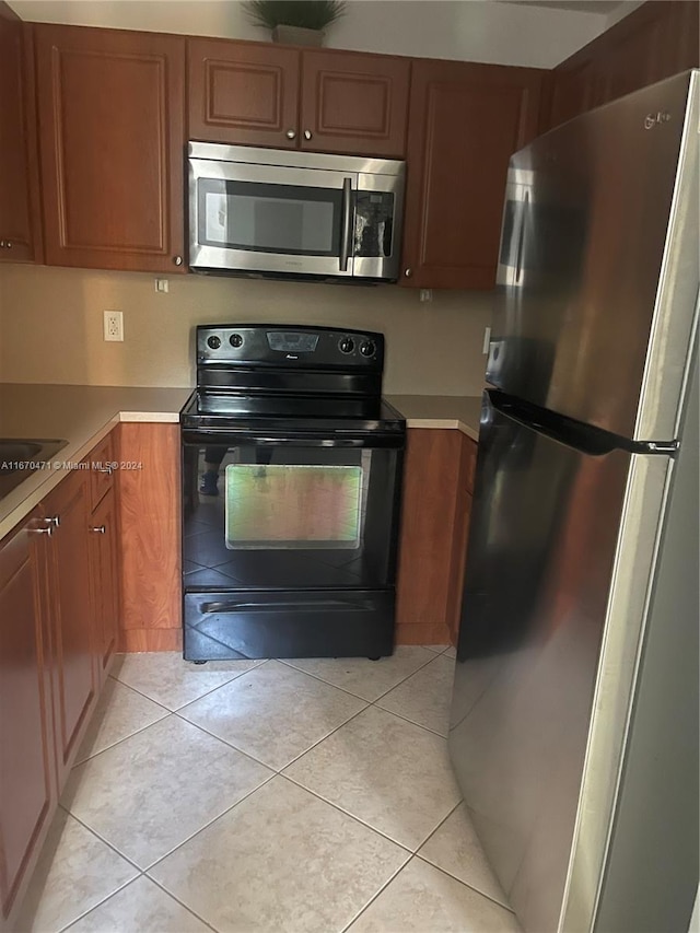 kitchen with stainless steel appliances and light tile patterned floors