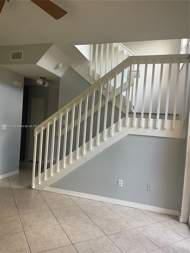 stairway featuring ceiling fan and tile patterned flooring