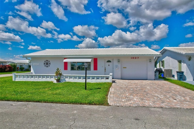 ranch-style house featuring an attached garage, a tile roof, a front yard, and decorative driveway