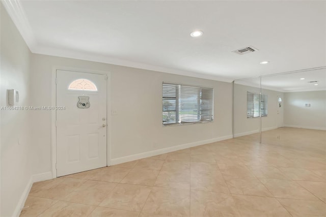 entrance foyer with light tile patterned flooring, baseboards, visible vents, and crown molding