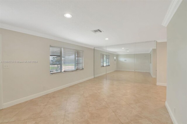 spare room featuring baseboards, visible vents, recessed lighting, crown molding, and light tile patterned floors