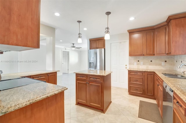 kitchen featuring a sink, brown cabinets, ceiling fan, appliances with stainless steel finishes, and hanging light fixtures