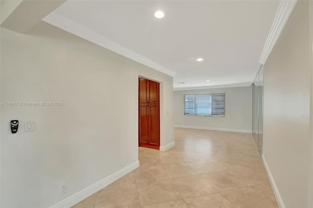 corridor featuring crown molding and light tile patterned floors