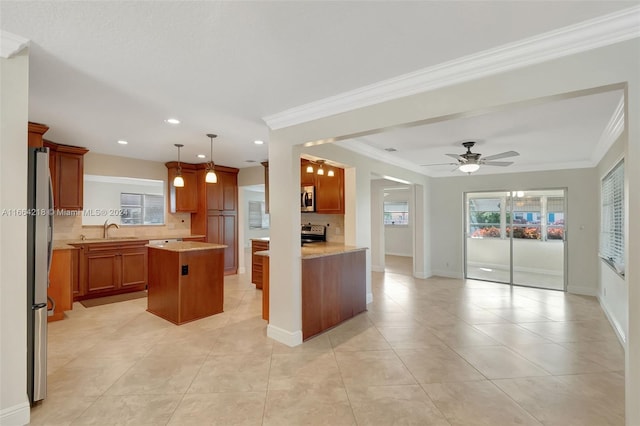 kitchen featuring sink, a kitchen island, decorative backsplash, stainless steel appliances, and ceiling fan