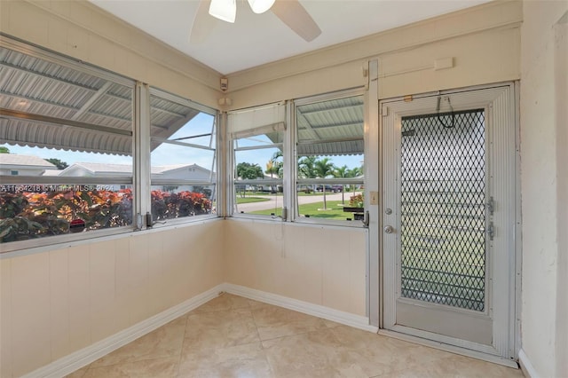 doorway to outside with a ceiling fan and baseboards