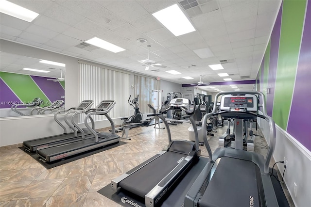 exercise room featuring a paneled ceiling, a ceiling fan, and visible vents