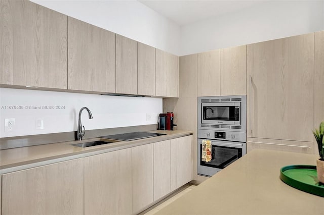 kitchen with stainless steel appliances, light brown cabinets, and sink