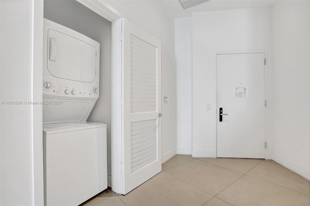 washroom featuring stacked washer / drying machine and light tile patterned floors