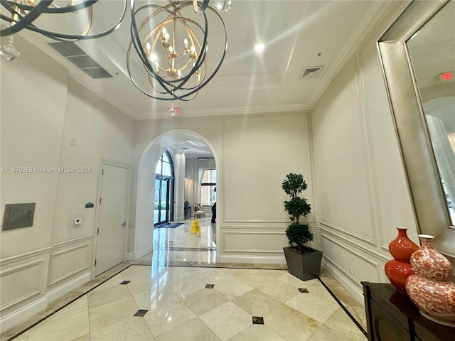 foyer entrance with a notable chandelier and ornamental molding