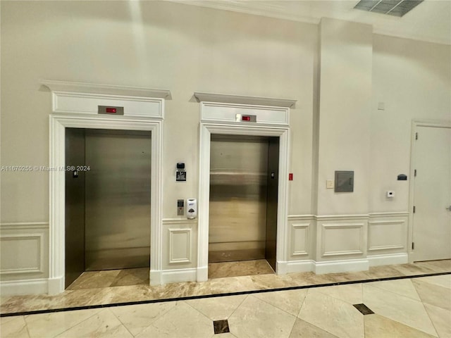 corridor featuring light tile patterned floors, ornamental molding, and elevator