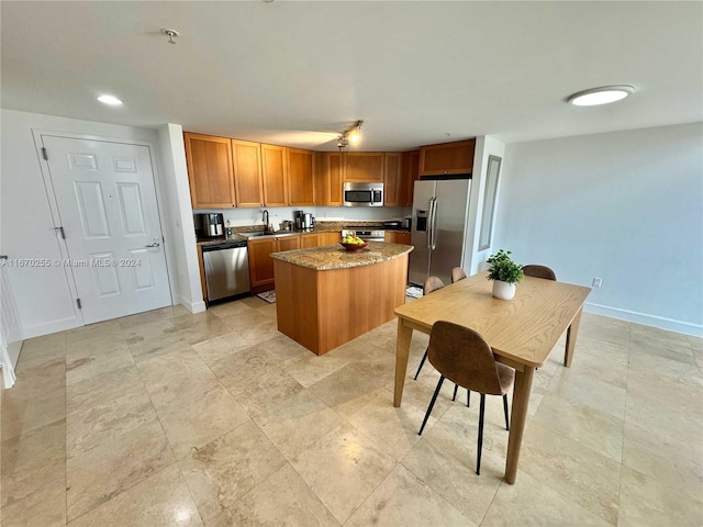 kitchen featuring dark stone countertops, appliances with stainless steel finishes, sink, and a kitchen island