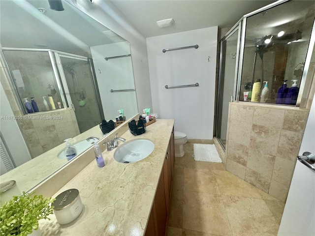 bathroom with vanity, tile patterned flooring, toilet, and an enclosed shower