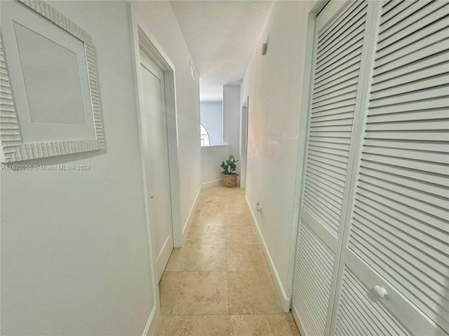 hall featuring a textured ceiling