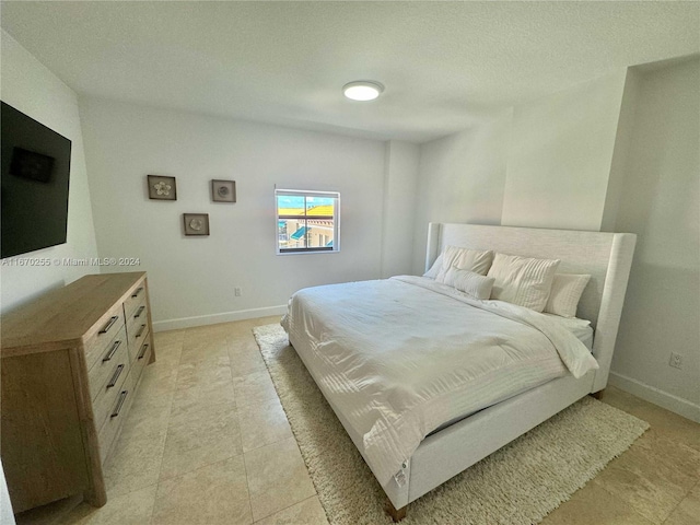 tiled bedroom featuring a textured ceiling