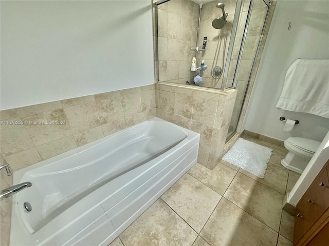 bathroom featuring tile patterned flooring, toilet, and plus walk in shower