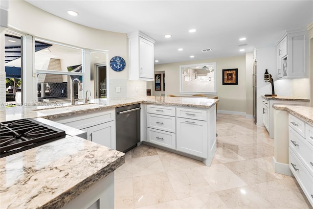 kitchen featuring white cabinets, kitchen peninsula, backsplash, and appliances with stainless steel finishes