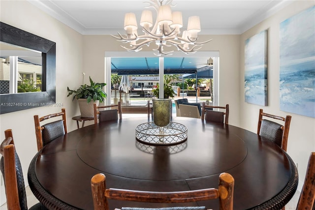 dining space featuring plenty of natural light, ornamental molding, and an inviting chandelier