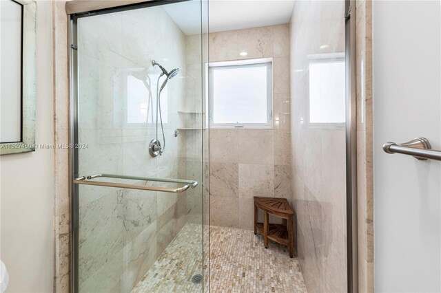 bathroom featuring a shower with shower door