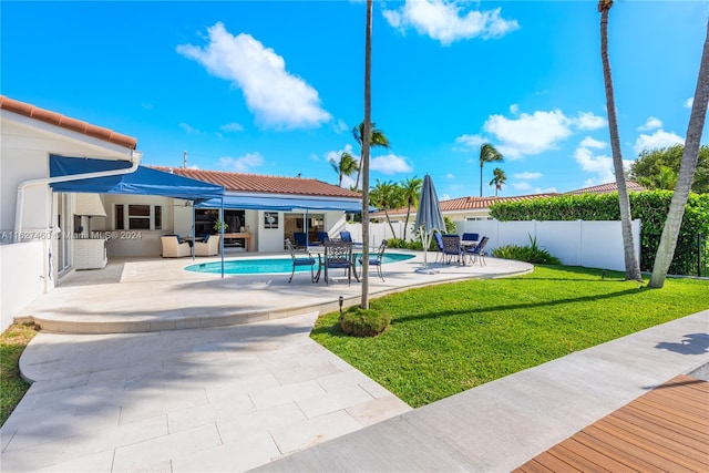 view of swimming pool with a patio, an outdoor kitchen, and a lawn