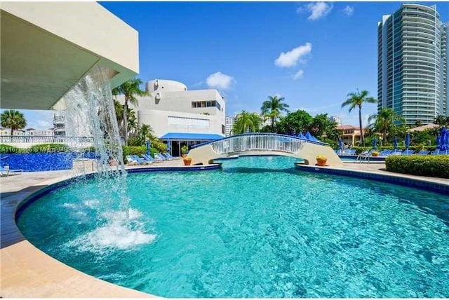 view of swimming pool featuring a jacuzzi, a patio, and pool water feature