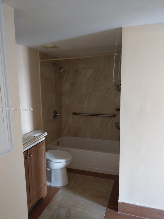 full bathroom with tile patterned flooring, tiled shower / bath, vanity, and toilet