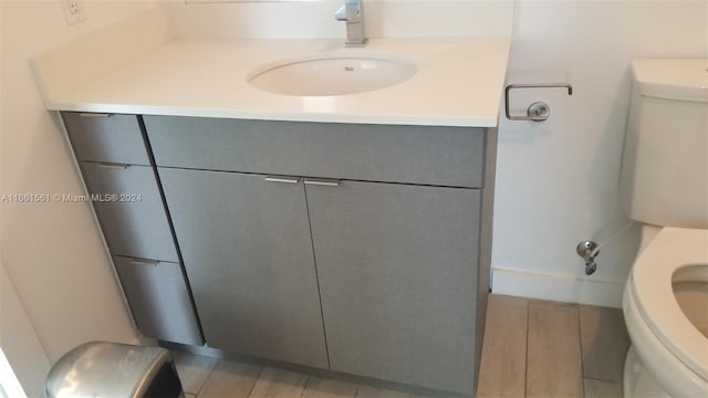 bathroom with hardwood / wood-style floors, vanity, and toilet