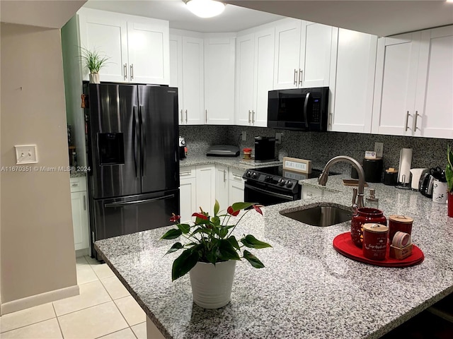 kitchen featuring light stone counters, kitchen peninsula, black appliances, backsplash, and white cabinetry