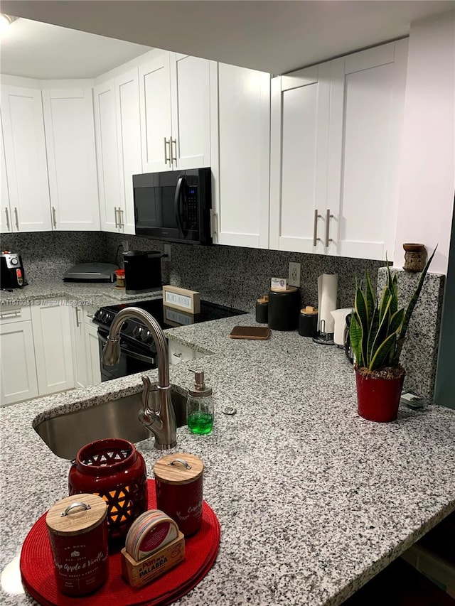 kitchen featuring white cabinetry, decorative backsplash, sink, and light stone counters