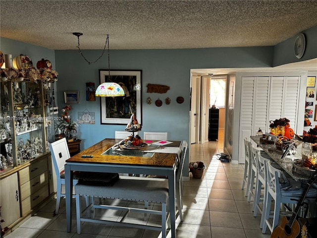 tiled dining space featuring a textured ceiling