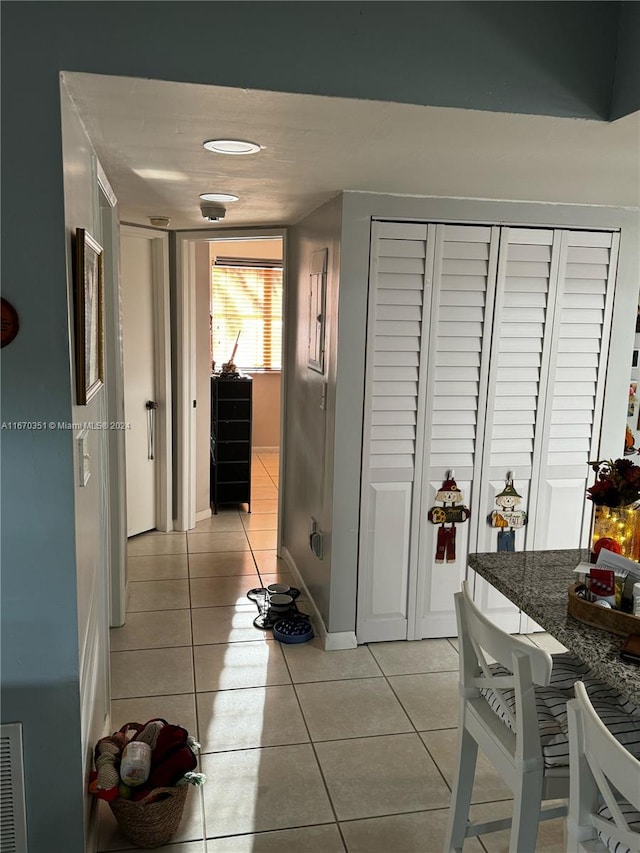 hall featuring light tile patterned flooring