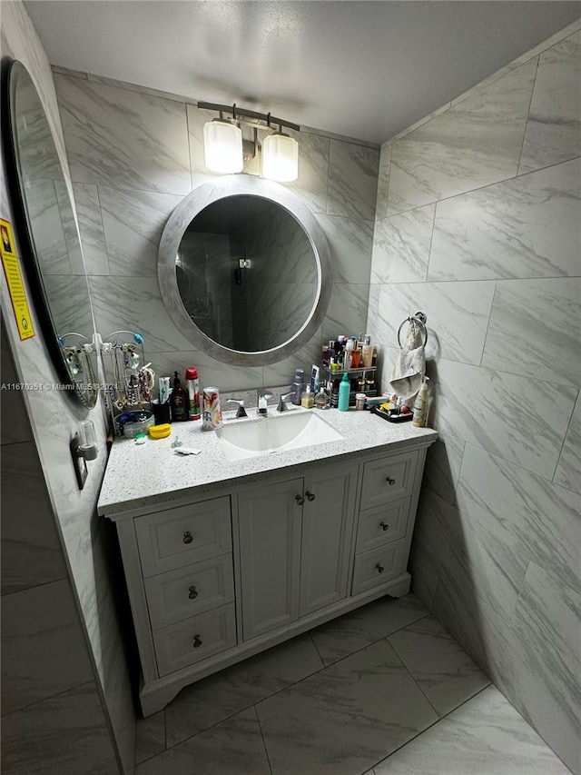 bathroom featuring vanity and tile walls