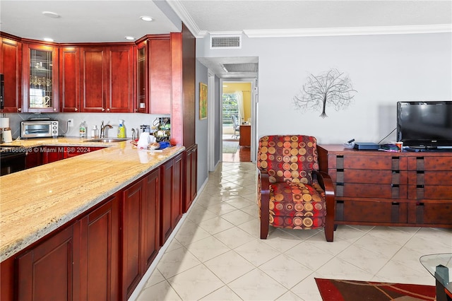 kitchen with light stone counters, crown molding, sink, and decorative backsplash