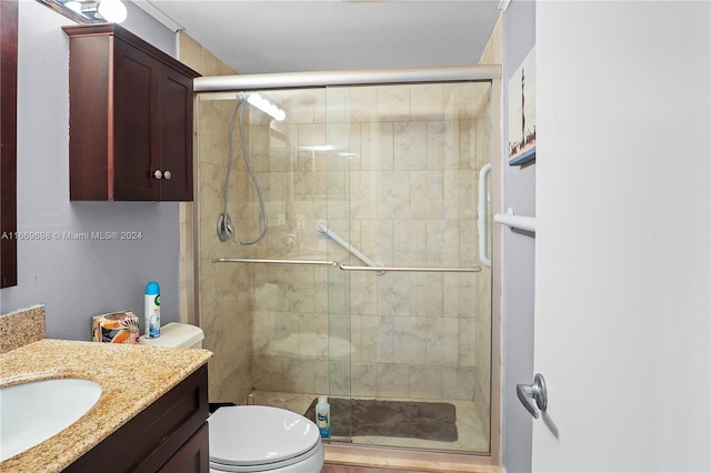 bathroom with walk in shower, vanity, and toilet