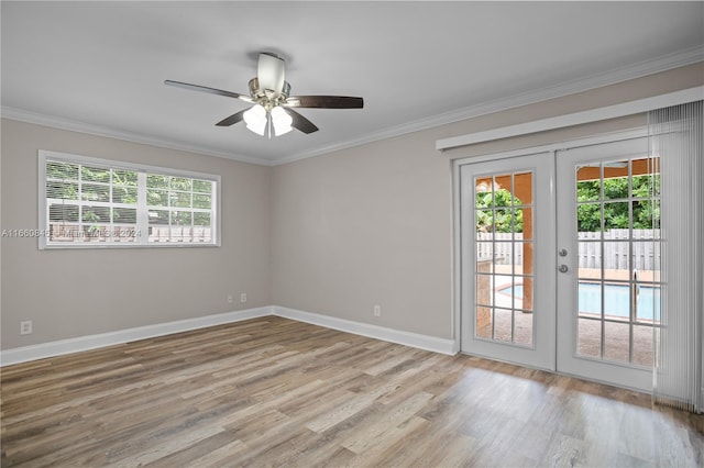 spare room with light wood-type flooring, crown molding, ceiling fan, and french doors