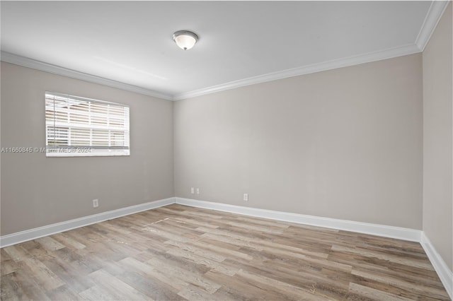 empty room with light hardwood / wood-style flooring and crown molding