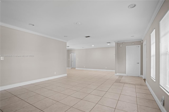 tiled spare room featuring a healthy amount of sunlight and ornamental molding