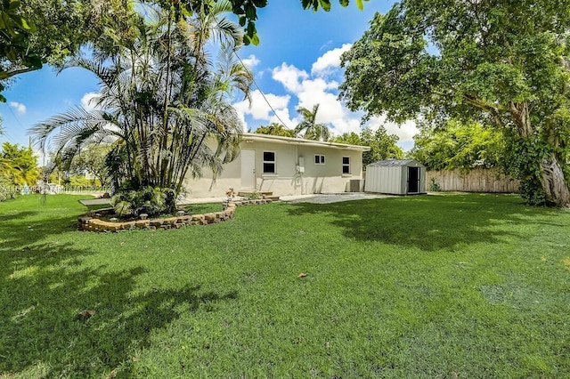 back of house featuring a lawn, a storage unit, and a patio area