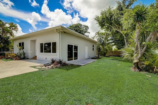 back of house featuring a patio area and a yard