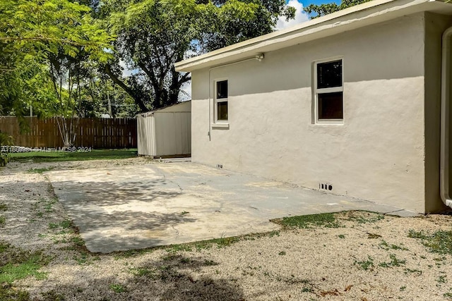 exterior space with a patio and a storage unit