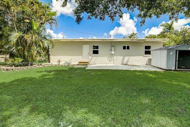 back of house with a storage unit, a patio area, and a yard