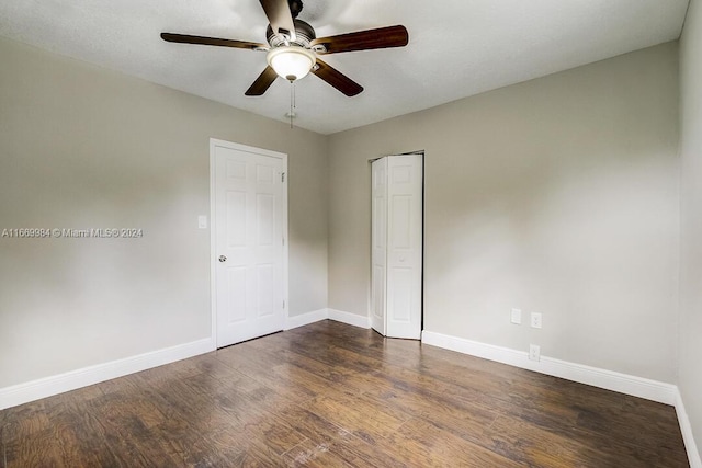 spare room with dark hardwood / wood-style flooring and ceiling fan