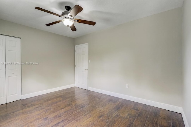 unfurnished room with ceiling fan and dark wood-type flooring