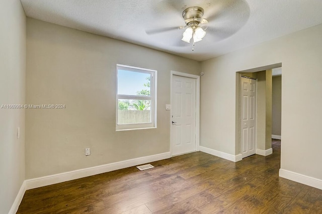 unfurnished room featuring a textured ceiling, dark hardwood / wood-style flooring, and ceiling fan