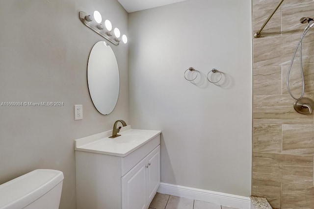 bathroom featuring tiled shower, vanity, toilet, and tile patterned floors