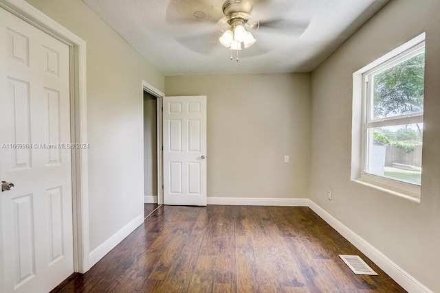 unfurnished bedroom featuring ceiling fan and dark wood-type flooring