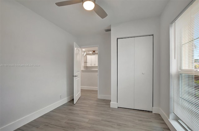 unfurnished bedroom featuring light hardwood / wood-style flooring, a closet, and ceiling fan